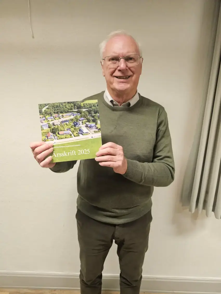 Mand i grøn trøje holder en bog