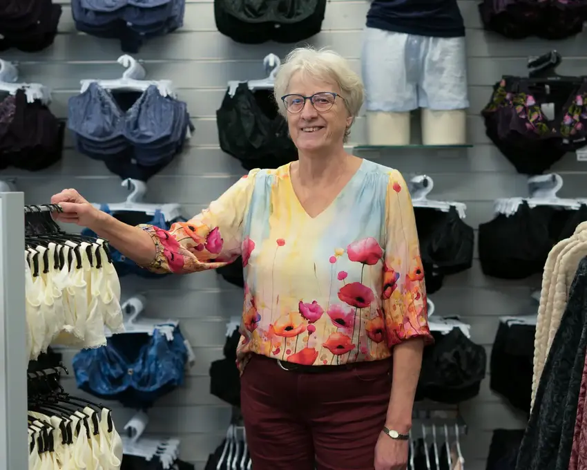 Ældre kvinde som står i tøjbutik