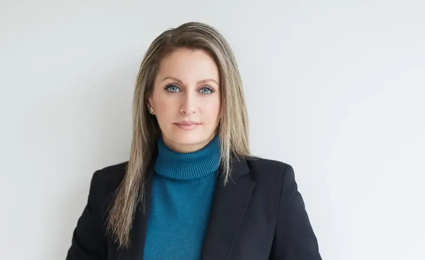 Smuk kvinde i blå trøje og mørk jakke