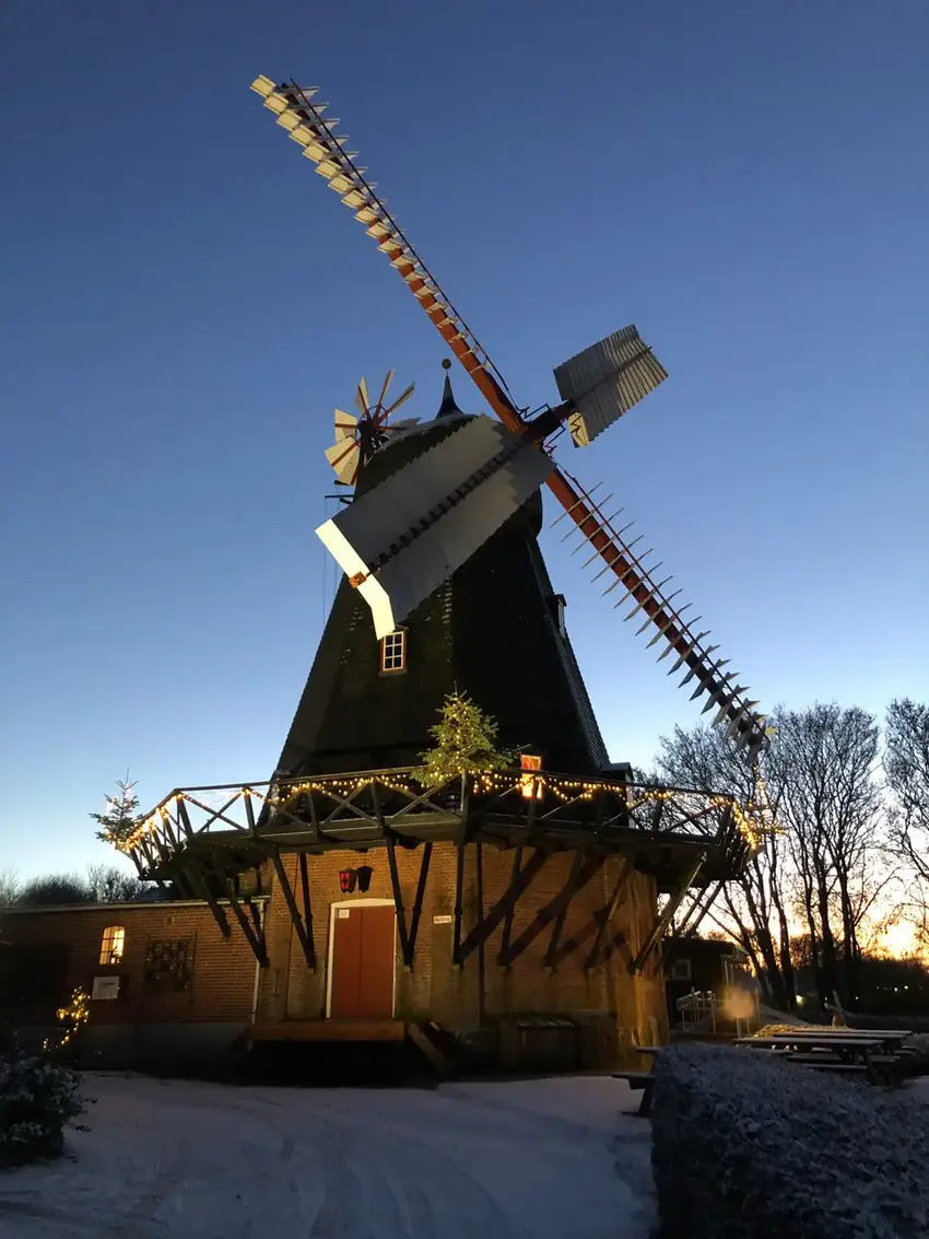 Gammel mølle med fire vinger mod blå aftenhimmel