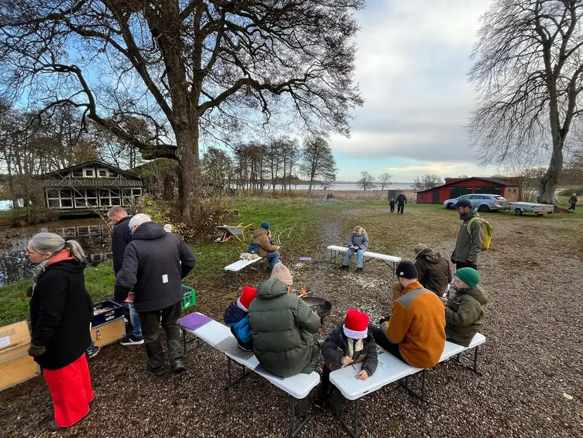 Mennesker ude i naturen med sø i baggrunden