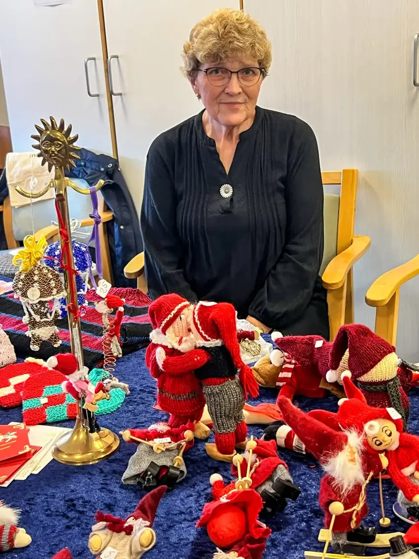 Kvinde står ved bord fyldt med nisser