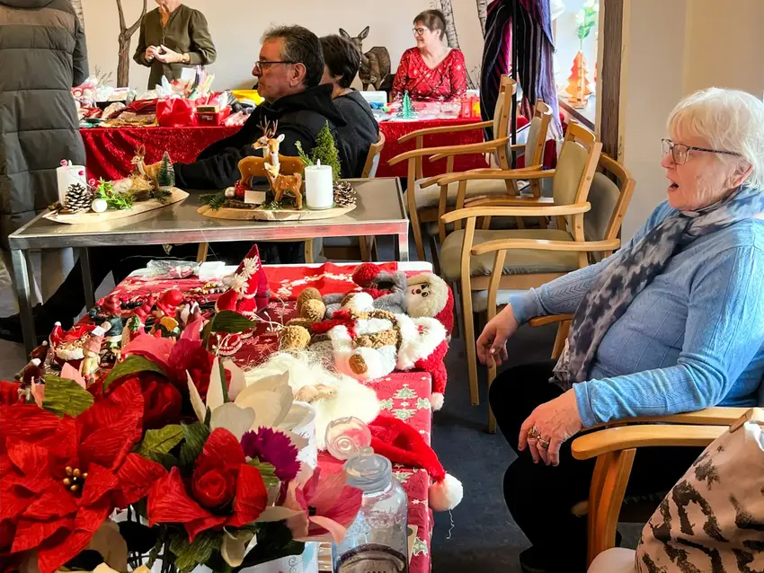 Kvinde sidder ved bord fyldt med nisser