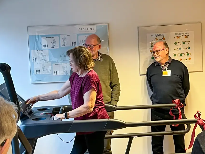 Marianne demonstrerer løbebåndet for Per og Ejlif