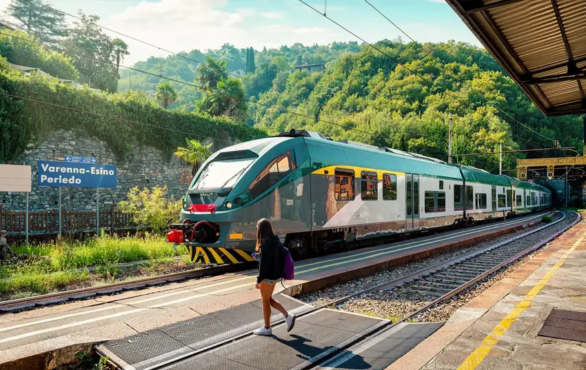 Flot grønt tog ved perronen i en Italiensk by