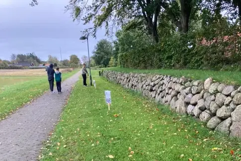 Børn som går på stisystem. Grønt græs i kanten