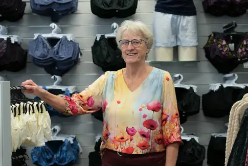 Ældre kvinde som står i tøjbutik