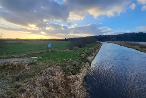 Billed af Kolindsund med grøn mark og blå himmel
