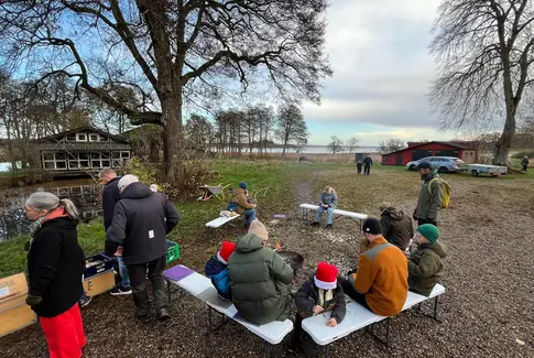 Mennesker ude i naturen med sø i baggrunden