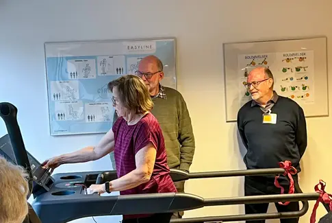 Marianne demonstrerer løbebåndet for Per og Ejlif